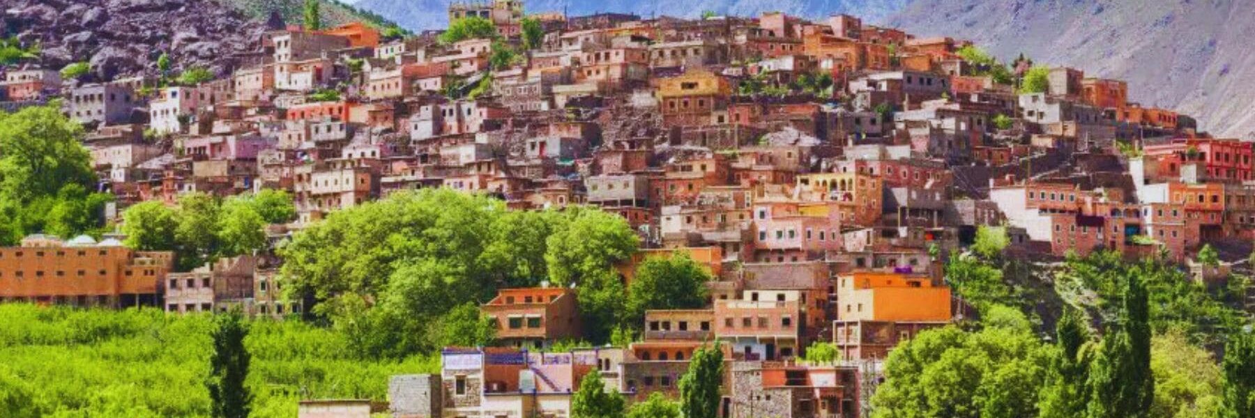 Winding road through green valleys and Berber villages in the Atlas Mountains.