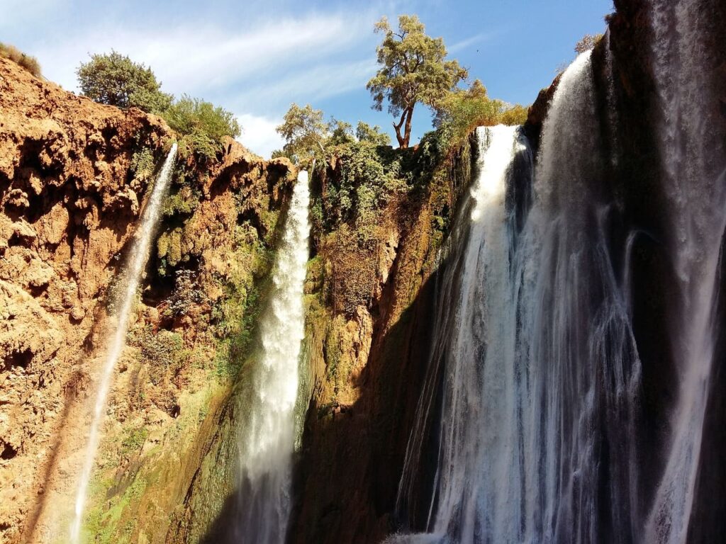 Ouzoud Waterfalls, the tallest in Morocco, cascading 110 meters surrounded by lush greenery in the Middle Atlas Mountains.